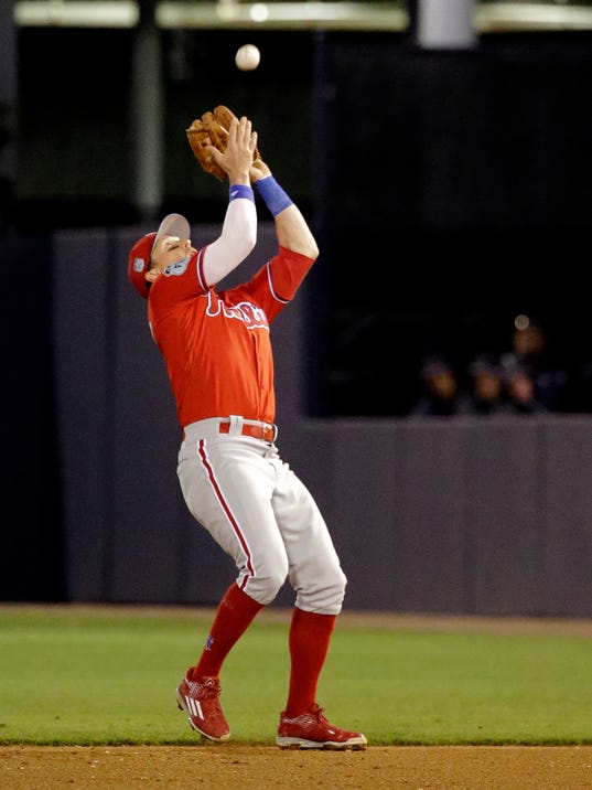 FILE - In this March 15, 2017, file photo, Philadelphia Phillies second baseman Chris Coghlan catches a pop fly in the fifth inning of a spring training baseball game in Tampa, Fla. Coghlan spent spring training with the Phillies using a wrist band to measure his sleep and recovery.(AP Photo/John Raoux)