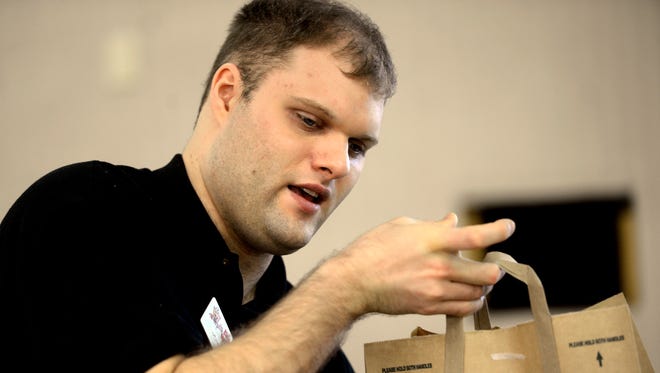 Mitch Matthiesen bags groceries at Olsen's Piggly Wiggly in Howard. Blind and autistic, Matthiesen earned an award for his efforts in the workplace.