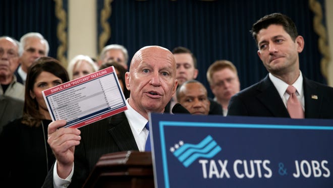 House Ways and Means Committee Chairman Kevin Brady, R-Texas, joined by Speaker of the House Paul Ryan, R-Wis., right, holds a proposed "postcard tax filing form" as they unveil the GOP's far-reaching tax overhaul, the first major revamp of the tax system in three decades, on Capitol Hill in Washington, Thursday, Nov. 2, 2017. (AP Photo/J. Scott Applewhite)