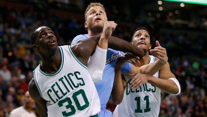 Boston Celtics forward Brandon Bass and guard Evan Turner battle for the rebound with Los Angeles Clippers forward Blake Griffin at TD Garden.