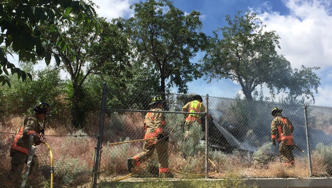 Reno Fire Department battles a small brush fire near Interstate 80 on Thursday