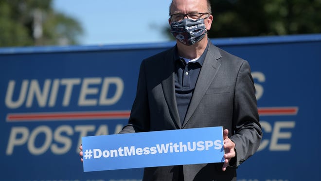 U.S. Rep. James P. McGovern holds a hashtag sign Tuesday at the United States Postal Service center in Shrewsbury.