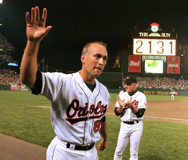 Cal Ripken Jr. waves to the crowd as the sign in centerfield reads 2,131, signifying Ripken had broken Lou Gehrig's record of playing in 2,130 consecutive games.