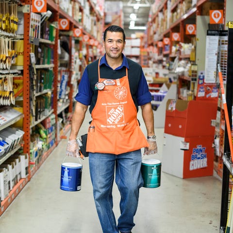 A Home Depot employee carrying paint cans.