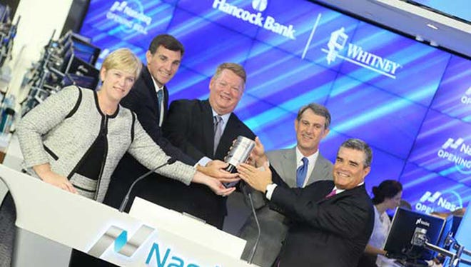 Hancock Holding Company executives opened The Nasdaq Stock Market recently to honor the strong spirit of people and places affected by Hurricane Katrina. Pictured (from left) are Investor Relations Manager Trisha Carlson, Chief Operating Officer Shane Loper, President & CEO John Hairston, Chief Financial Officer Mike Achary, and Whitney Bank President Joe Exnicios.