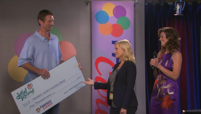 Detlef Schrempf provides a check during Leslie Knope's telethon.