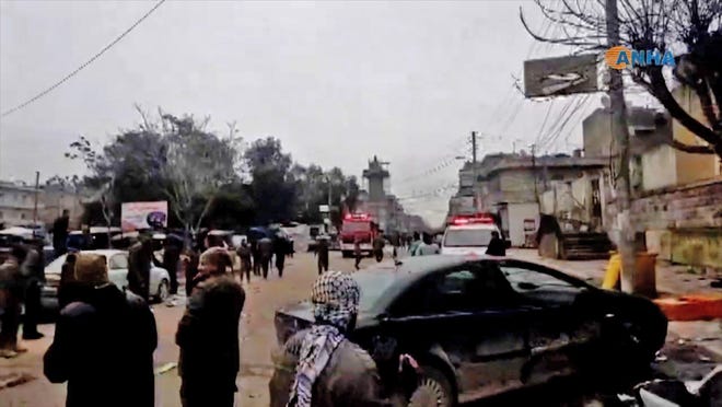 An image grab taken from a video published by Hawar News Agency (ANHA) on Jan. 16, 2019, shows people gathered at the scene of a suicide attack in the northern Syrian town of Manbij. The suicide attack targeted US-led coalition forces in the flashpoint northern Syrian city of Manbij.