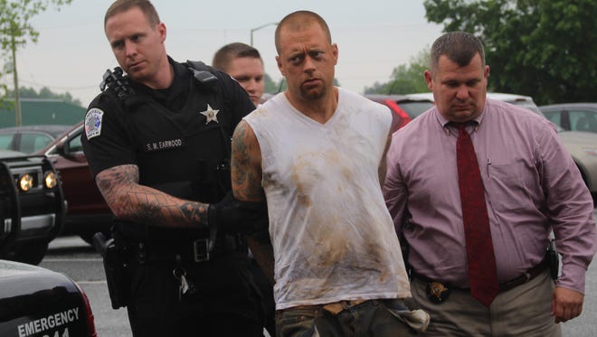 Zachary Earl Powell, center, is led into the Anderson County Sheriff's Office in Anderson on Thursday. He was apprehended by Anderson police near South Main and Franklin streets.