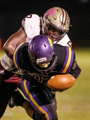 Brebeuf Jesuit Braves Jay Higgins (44) forces a fumble by knocking the ball out of the hands of Guerin Catholic Golden Eagles running back Thomas Kaser (22) in the first half of their game at Guerin Catholic High School in Nobelsville, Friday, Oct 20, 2017. 