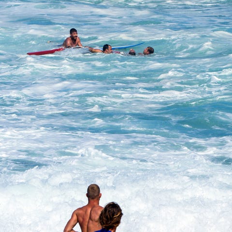 Bodyboarder Andre Botha, top left, watches as two 