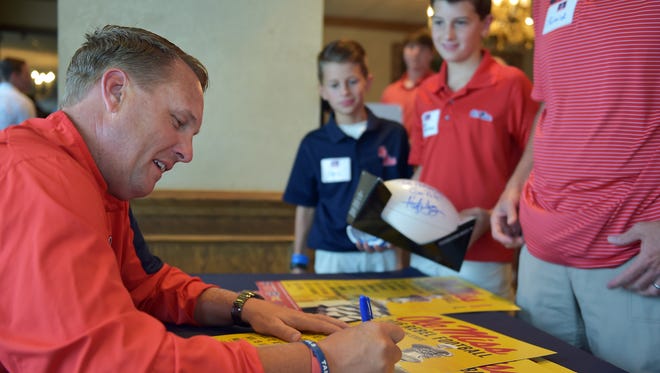 Ole Miss football coach Hugh Freeze signs autographs for fans at the Jackson County Club during a stop on the 2016 Rebel Road Trip Tuesday.