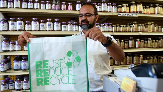 The Teaneck Township Council recently passed a 5-cent plastic bag fee. Zuly Ahmed, owner of Aquarius Health Foods, shows a reusable bag on Tuesday.