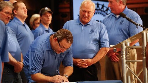 UAW President Dennis Williams, center, watches as Volkswagen Chattanooga employee Jonathan Walden signs the UAW charter last July 10, at the IBEW Local 175 in Chattanooga to announce formation of UAW Local 42.