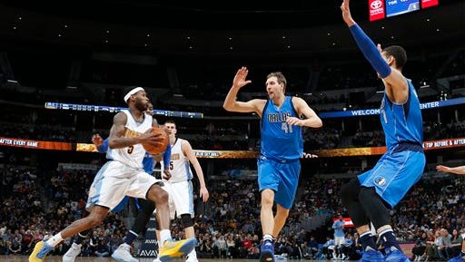 Denver Nuggets forward Will Barton, left, drives for a basket as Dallas Mavericks forwards Dirk Nowitzki, center, of Germany, and Dwight Powell defend in the second half of an NBA basketball game Monday, March 28, 2016, in Denver. The Mavericks won 97-88. (AP Photo/David Zalubowski)
