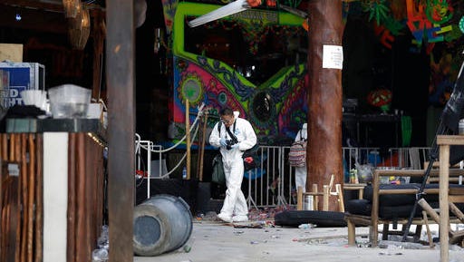 A forensic investigator walks inside the Blue Parrot club, one day after a deadly early morning shooting in Playa del Carmen, Mexico, Tuesday, Jan. 17, 2017. Mexican authorities said Tuesday they are investigating whether extortion, street-level drug sales or a murder plot was the motive behind a shooting at an electronic music festival at a Caribbean resort town that left three foreigners and two Mexicans dead.