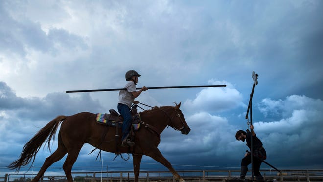 Devin Nerone, 14, charges the quintain with a practice lance while one of the troupe's's squires, Alexander Butterfield, ducks on Saturday, June 30, 2018, at the Alperose Ranch in Fort Collins, Colo. The Order of Epona, a medieval and fantasy equestrian performance troupe, opened up their arena to introduce equestrians to some of the games commonly played in medieval times, and will be training for the jousting competition and performances at the upcoming Longs Peak Scottish Irish Highland Festival next September in Estes Park, Colo.