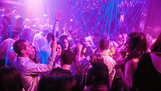 The crowd dances in the lasers during the grand opening of Cake Nightclub in Scottsdale on Jan. 11, 2014.