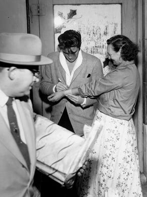 An unidentified woman approached Elvis Presley at Goodfellows headquarters Dec. 16, 1957, with a request: 'Elvis, please autograph my arm!' Elvis was at the headquarters to present the Press-Scimitar Goodfellows with 100 brand new $10 bills. Elvis let it be known that the Goodfellows had played Santa Claus for him seven years earlier. 'Our family had it pretty rough that year,' he recalled. 'The Goodfellows made my Christmas for me.'
