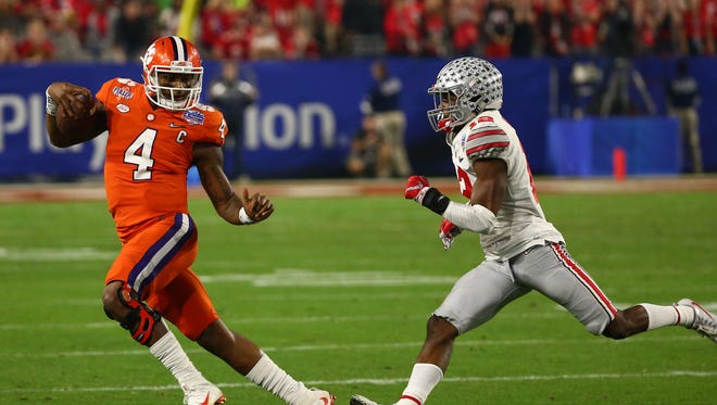Clemson Tigers quarterback Deshaun Watson (4) runs the ball as Ohio State Buckeyes cornerback Denzel Ward (12) looks to make a tackle during the second quarter of the College Football Playoff Semifinal game in the PlayStation Fiesta Bowl on Dec. 31, 2016 at University of Phoenix Stadium in Glendale, Arizona.