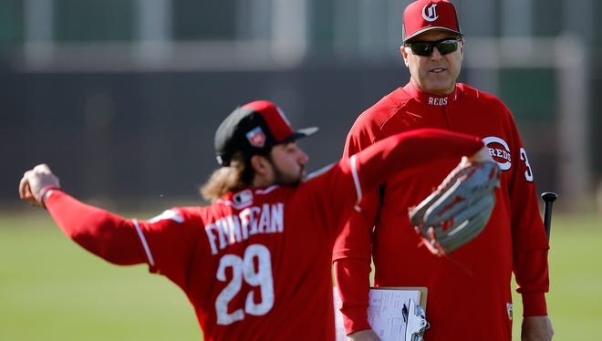 Cincinnati Reds manager Bryan Price (38) talks with starting pitcher Brandon Finnegan (29) as he warms up during practice at the Cincinnati Reds training complex in Goodyear, Ariz., on Wednesday, Feb. 21, 2018.