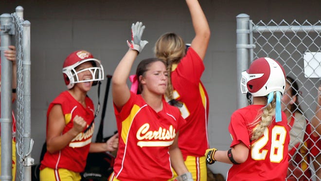 Carlisle's Katie Berg, right, was welcomed to the dugout after scoring in the second inning against Oskaloosa in a Class 4-A quarterfinal Monday.