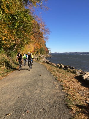 A group of cyclists ride along the bike path between the Palisades and the Hudson River north of Nyack, N.Y.