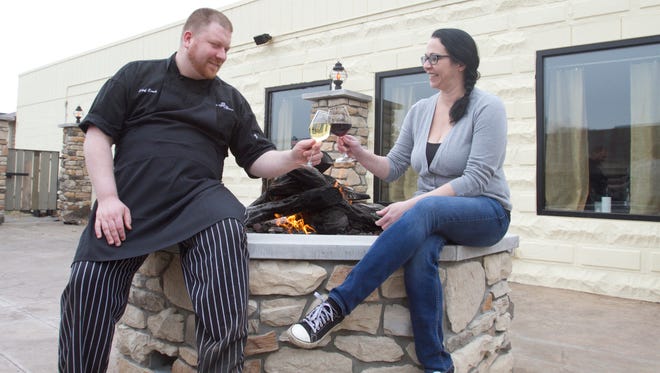 La Vita Bistro chef Eirik Kauserud and sommelier Shannon LaVigne clink glasses of a 2011 Gavi (Kauserud) and a 2009 Farina Barolo. Both wines are offered at the downtown Pinckney restaurant, where patrons have several choices of dining styles from formal to communal to dining outside by the fire.
