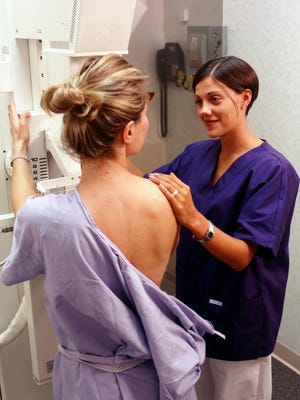 Nurse positioning patient for mammogram
