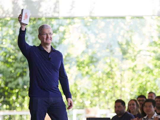 CEO Tim Cook holding the billionth iPhone.