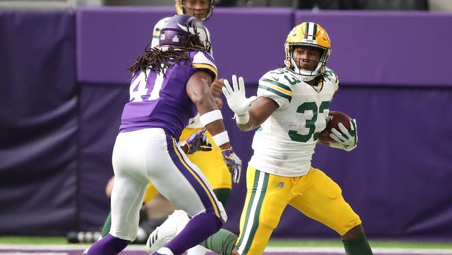 Green Bay Packers running back Aaron Jones (33) runs the ball against Minnesota Vikings free safety Anthony Harris (41) on Sunday, Oct. 15, 2017.