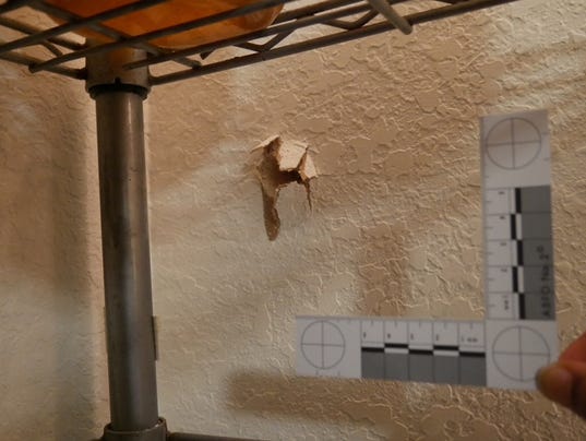 A woman's bedroom wall after  a bullet was shot through it.