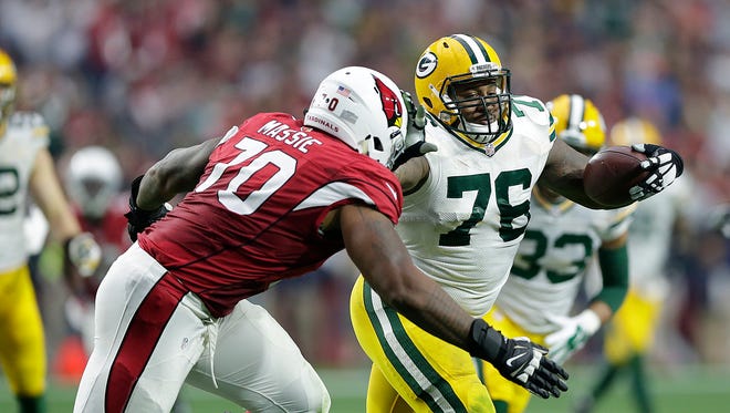 Green Bay Packers defensive tackle Mike Daniels (76) runs with the ball after making an interception against the Arizona Cardinals at University of Phoenix Stadium.