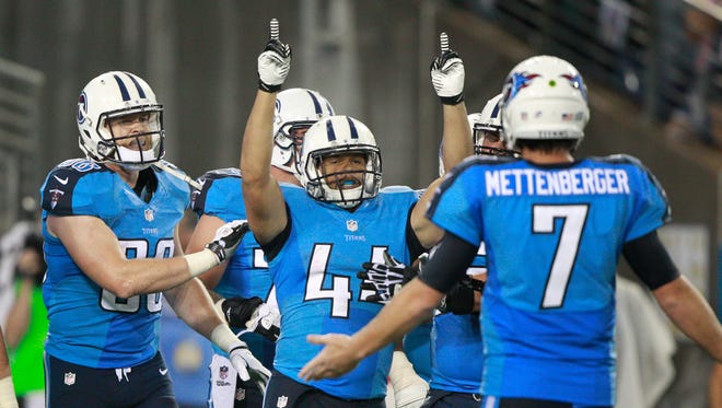 Tennessee Titans running back Jackie Battle (44) celebrates with quarterback Zach Mettenberger, right, and tight end Chase Coffman, left, after scoring a touchdown against the Green Bay Packers in the fourth quarter on Saturday.