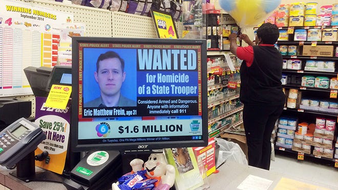 Displayed at a grocery store is a wanted advertisement for Eric Frein on Saturday, , in Philadelphia.  Police have charged Frein with opening fire outside a state police barracks in northeastern Pennsylvania on Sept. 12.  Cpl. Bryon Dickson was killed and Trooper Alex Douglass was wounded by the gunman with a high-powered rifle.