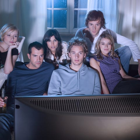 A group of young people watching TV together