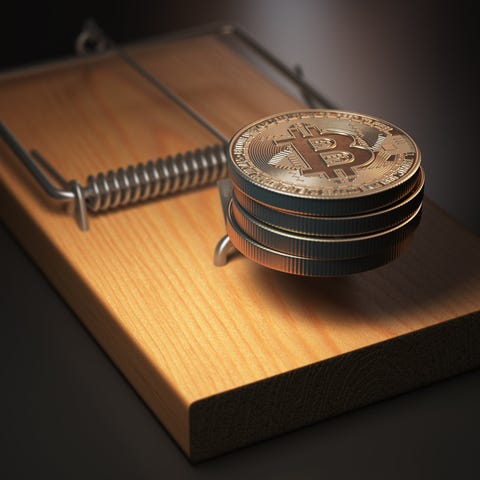 Physical bitcoin placed in a mouse trap.