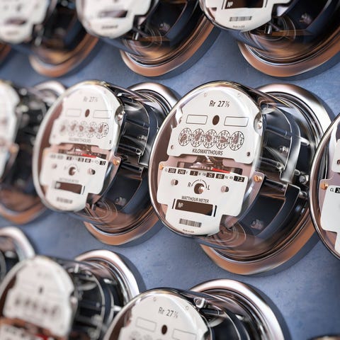 Multiple rows of electric meters on a panel.
