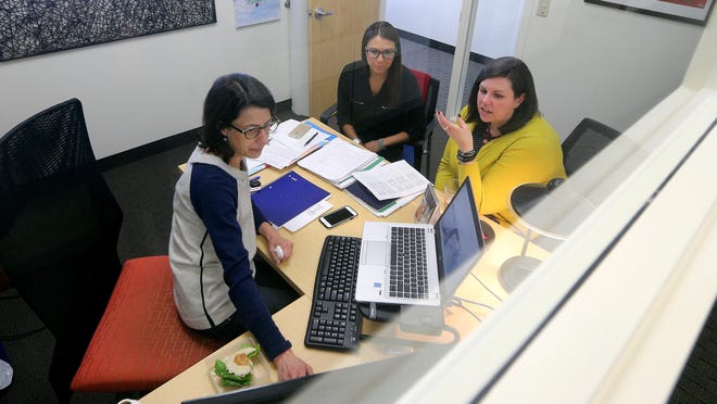 Andrea Zuegel, left, Chelsea Salitan, center, and Christine Falcipieri, employees of the account team at Butler/Till, have an office meeting.