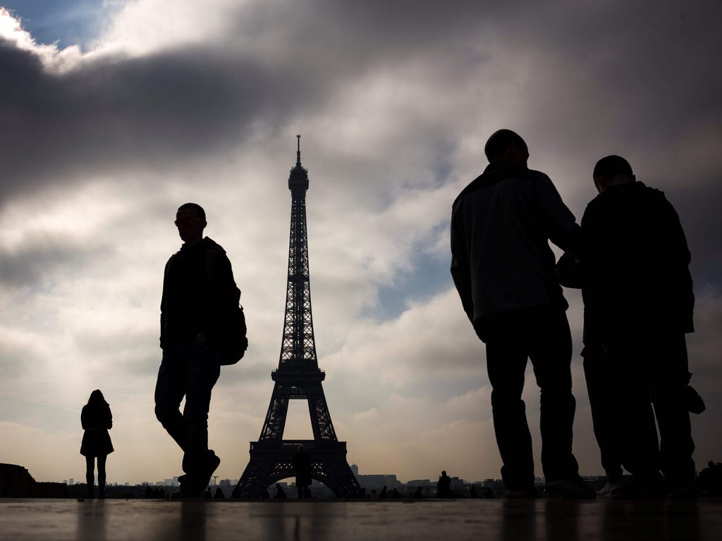 People walk in front of the Eiffel Tower in Paris.