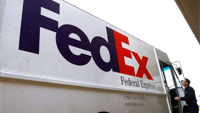 A Federal Express delivery truck driver return to his truck after delivering a package to a business Thursday, Dec. 18, 2014, in Springfield, Ill. (AP Photo/Seth Perlman) ORG XMIT: ILSP101
