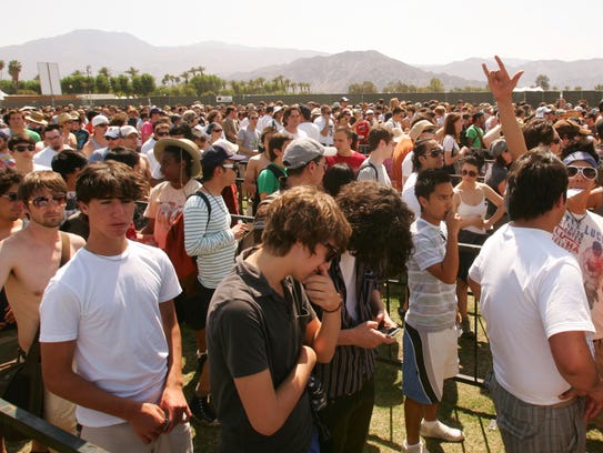 Festival goers wait in line for security searches before
