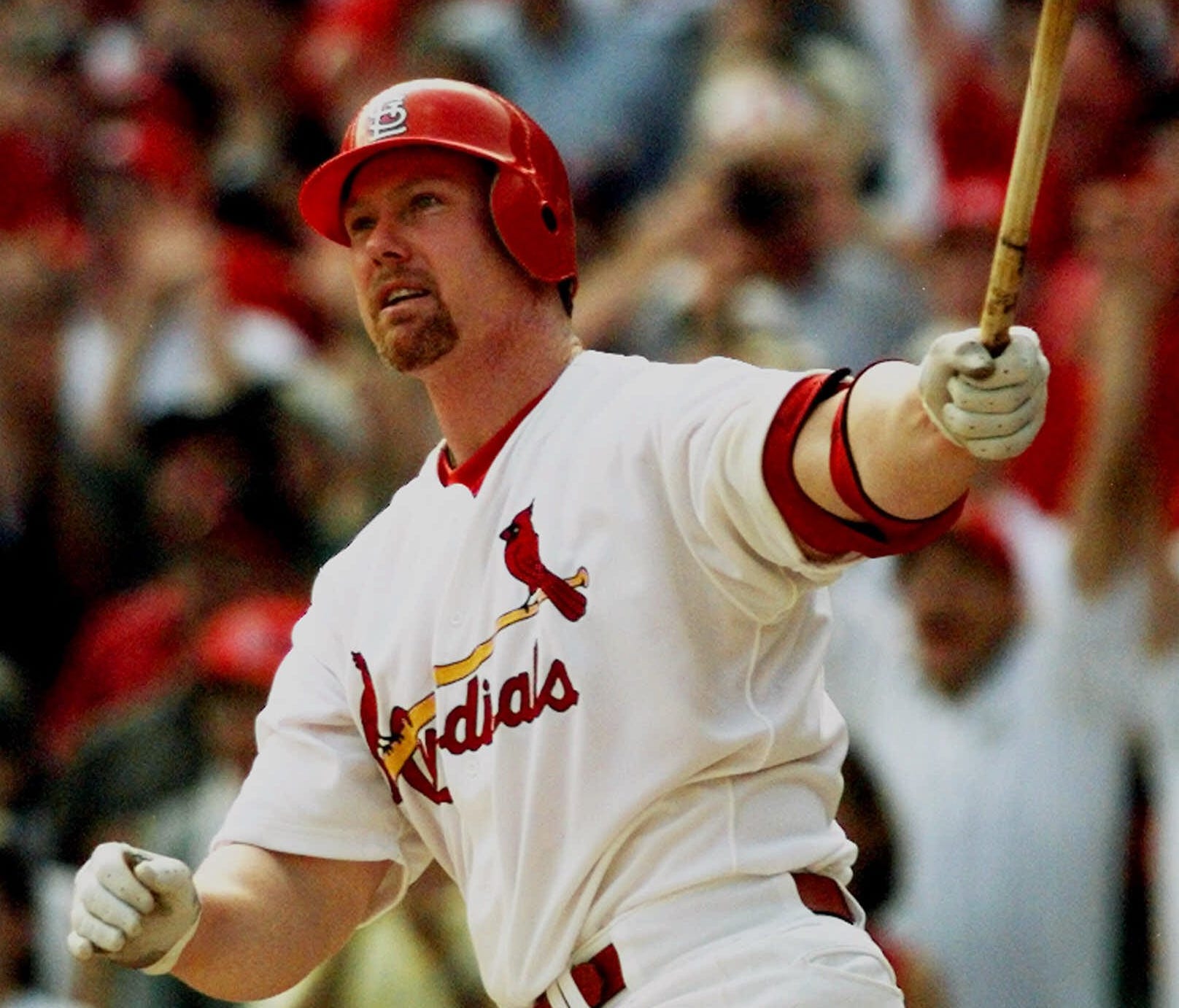 Mark McGwire watches his record-setting 70th home run against the Montreal Expos' Carl Pavano on Sept. 27, 1998.