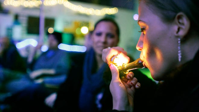 Rachel Schaefer of Denver smokes marijuana on the official opening night of Club 64, a marijuana-specific social club, where a New Year's Eve party was held in Denver on Dec. 31, 2012.