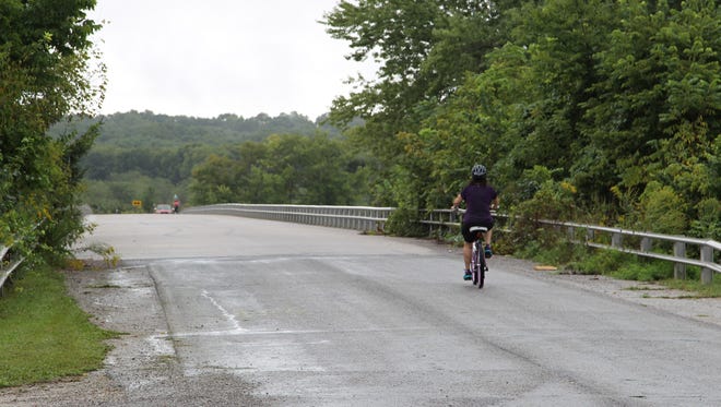 Milissa Leake cycles across the Wabash River as she makes it half way through her 35 mile bike ride.