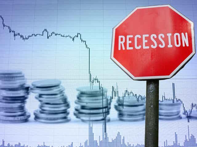 Red "recession" sign in front of a chart with a declining line.