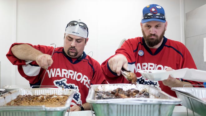  Mike Palmer, left, from Auburn Hills and Executive VP of the Michigan Warriors Disabled Veterans Hockey Program and Andy DeHoogh from Ferndale, prepare meals to be delivered to officers at their stations during the Detroit Police luncheon on Friday, July 15, 2016 at the Vietnam Veterans of America Post in Detroit. 