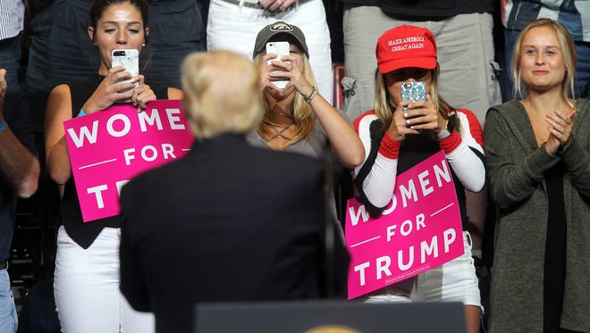 Guests take photos of President Donald Trump as he is introduced at the U.S. Cellular Center in Cedar Rapids on Wednesday, June 21, 2017. 