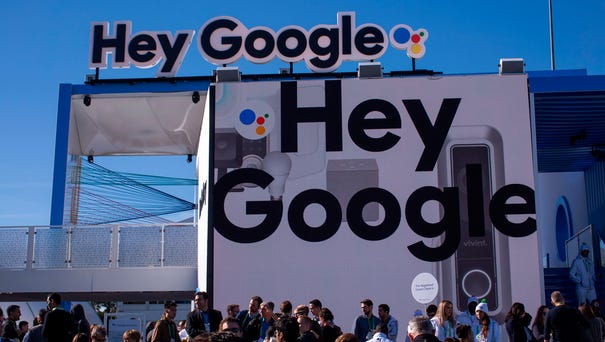 People walk past the Google exhibit during CES...
