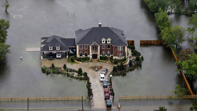 A home is surrounded by floodwaters from Tropical Storm Harvey on Tuesday, Aug. 29, 2017, in Houston.