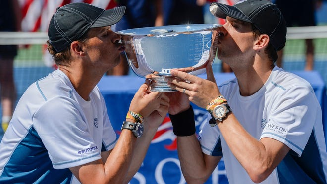 Bob, left, and Mike Bryan kiss the U.S. Open trophy after winning the men's doubles title in 2014.